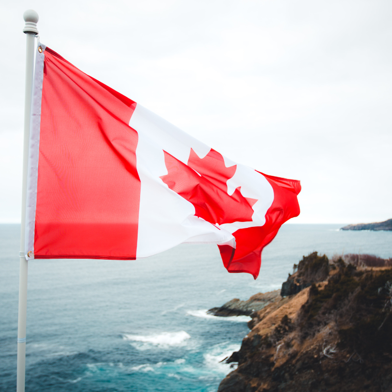 Canadian Flag, ocean in the background.