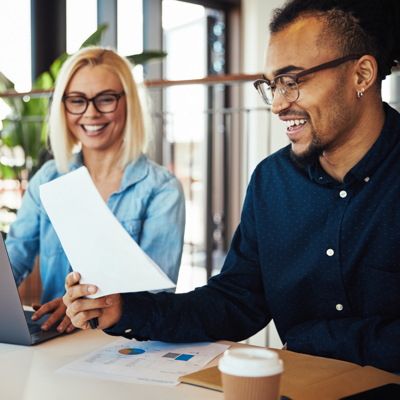 stock image of 2 people looking at a paper, used to build relevance towards intra company myths vs facts page.